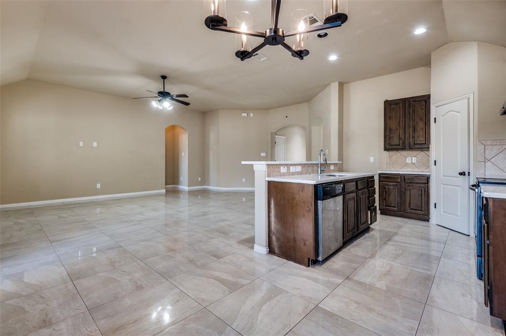 1615 Ridgemar Drive Grand Prairie, TX 75051 - Photo 19 of 25 a kitchen with kitchen island a sink a counter top space appliances and cabinets