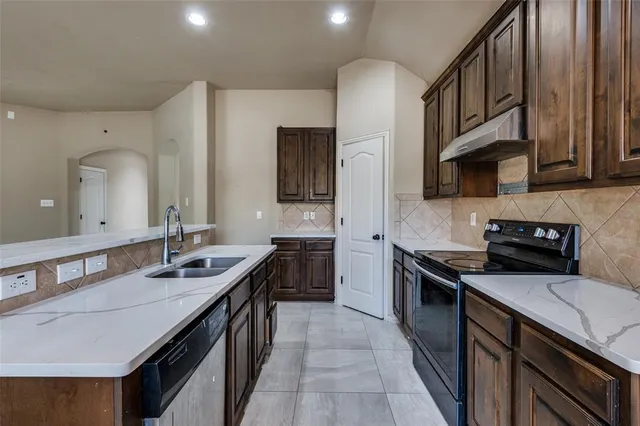 a kitchen that has a sink and a stove in it
