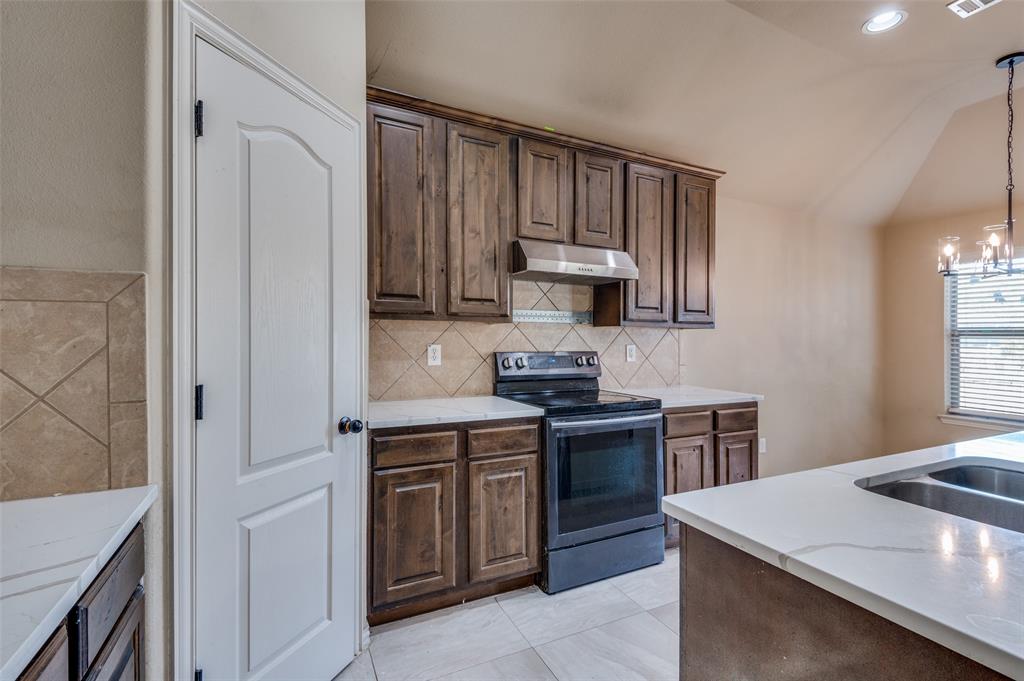 1615 Ridgemar Drive Grand Prairie, TX 75051 - Photo 21 of 25 a kitchen that has a sink and a stove in it