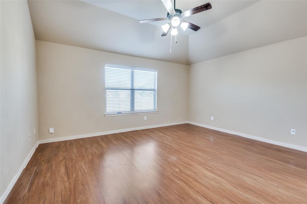 1615 Ridgemar Drive Grand Prairie, TX 75051 - Photo 22 of 25 an empty room with wooden floor fan and windows