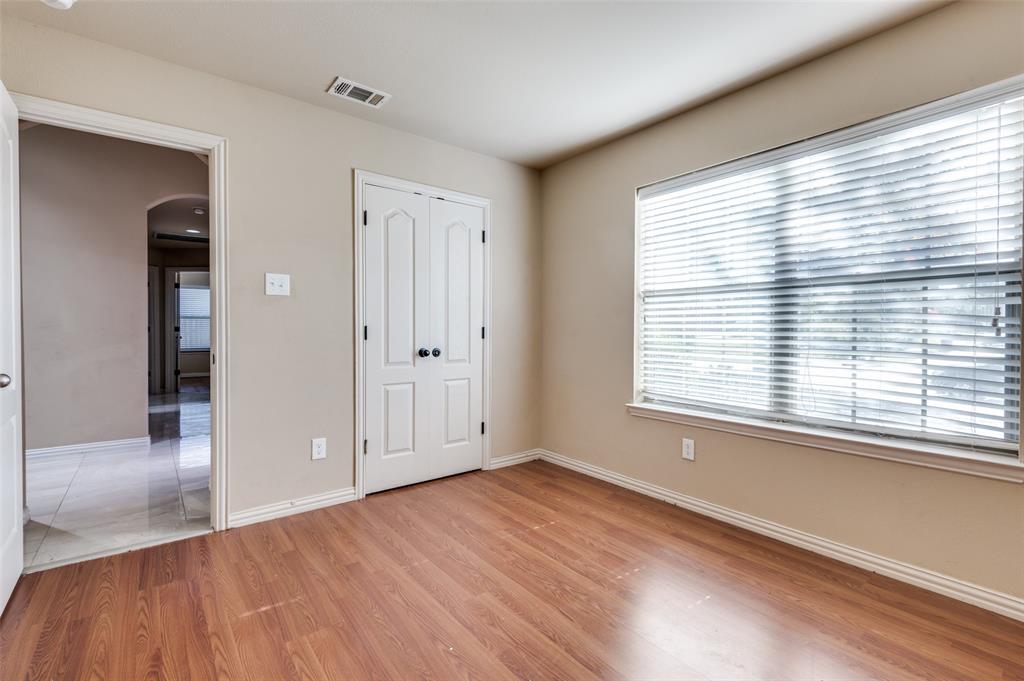 1615 Ridgemar Drive Grand Prairie, TX 75051 - Photo 5 of 25 a view of an empty room with wooden floor and a window