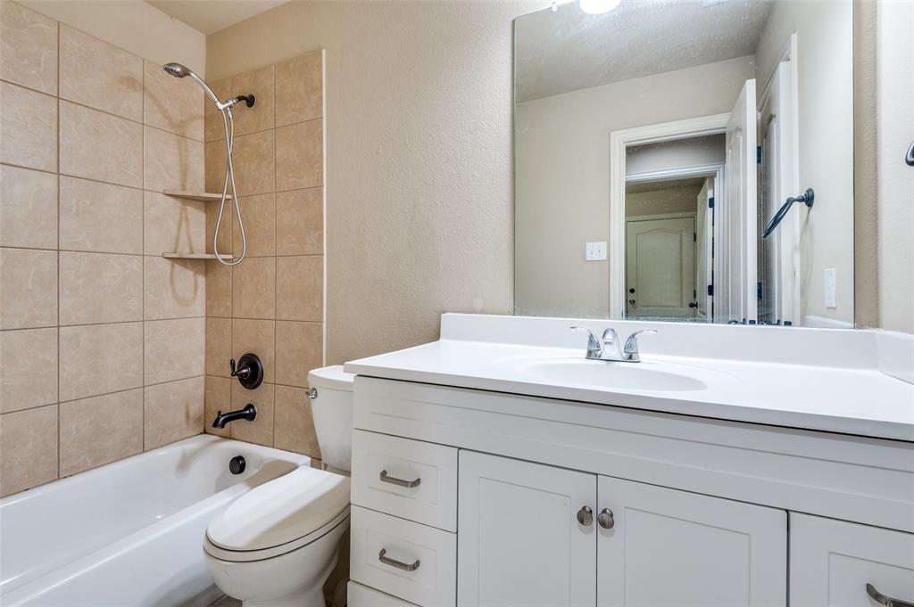1615 Ridgemar Drive Grand Prairie, TX 75051 - Photo 7 of 25 a bathroom with a granite countertop sink a toilet and shower