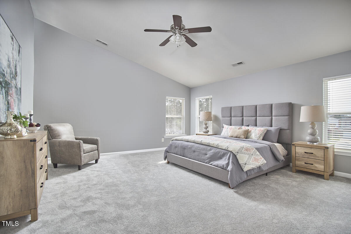442 Steel Hopper Way Garner, NC 27529 - Photo 25 of 45 a spacious bedroom with a bed and a chandelier