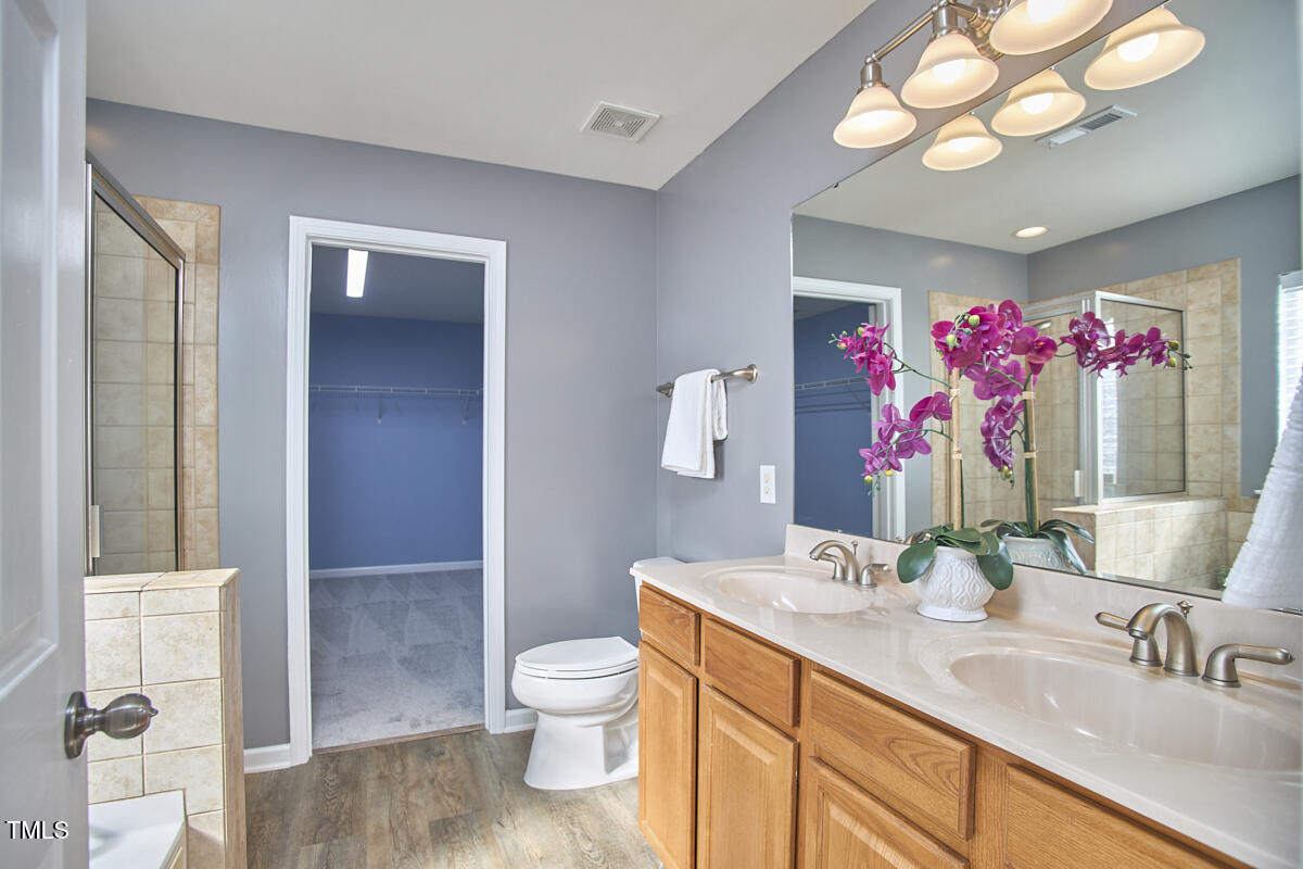 442 Steel Hopper Way Garner, NC 27529 - Photo 27 of 45 a bathroom with a sink vanity mirror and toilet