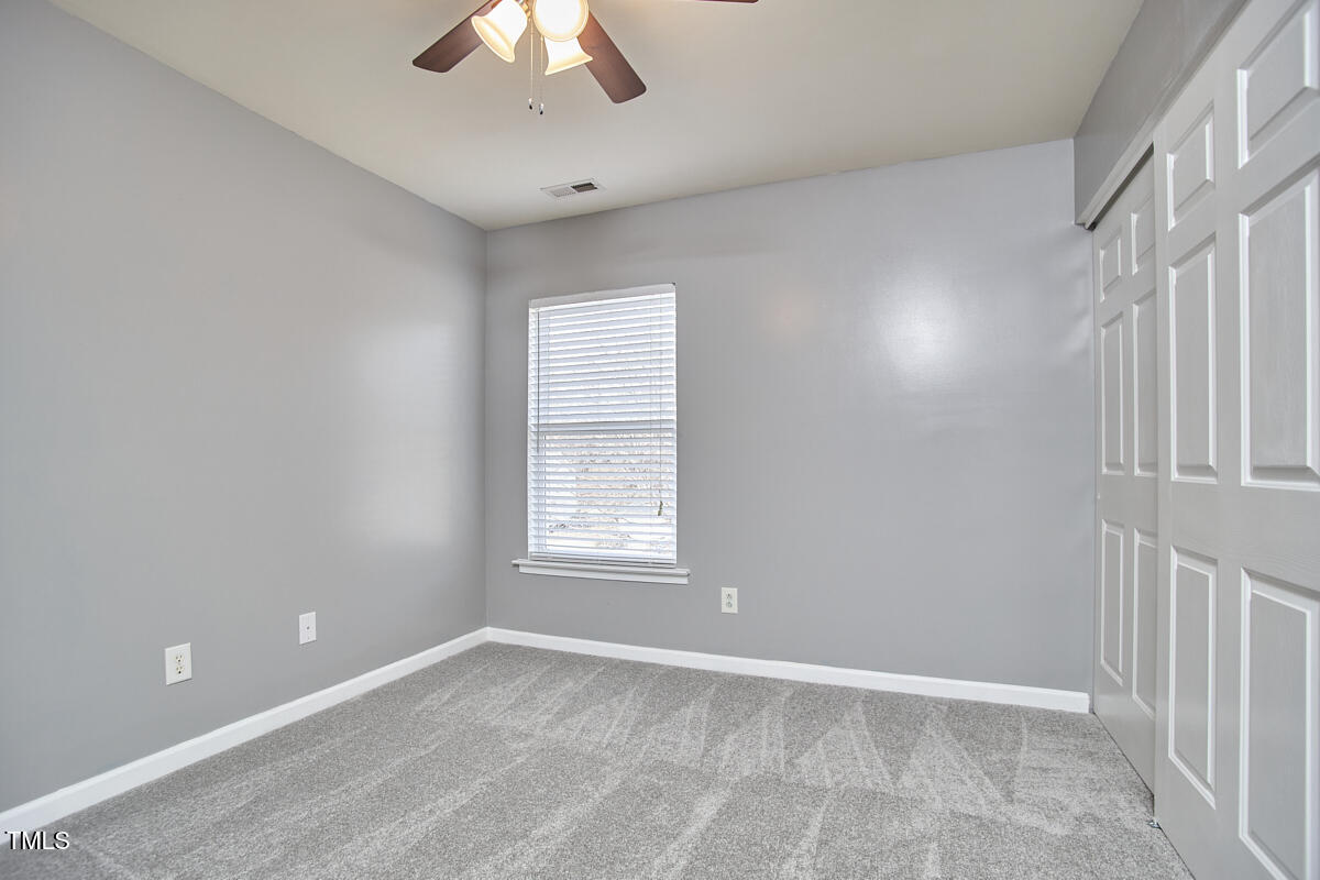 442 Steel Hopper Way Garner, NC 27529 - Photo 34 of 45 an empty room with a window and a fan