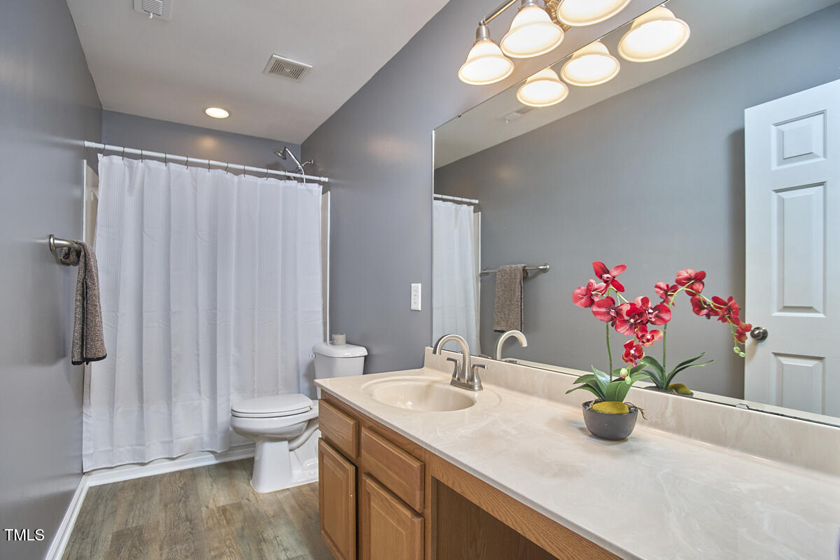 442 Steel Hopper Way Garner, NC 27529 - Photo 35 of 45 a bathroom with a granite countertop sink a large mirror and a shower
