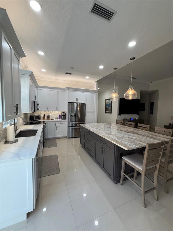 2752 Irma Lake Drive West Palm Beach, FL 33411 - Photo 11 of 38 a kitchen with stainless steel appliances granite countertop a sink counter space and a stove top oven