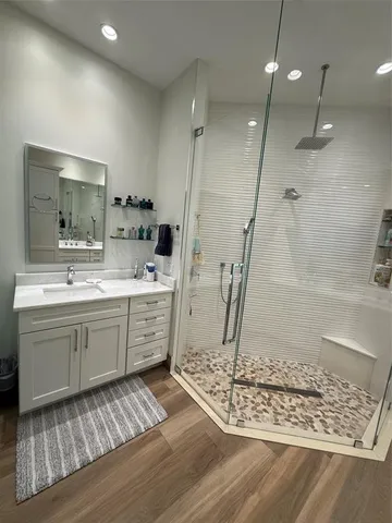 a bathroom with a glass shower sink and mirror