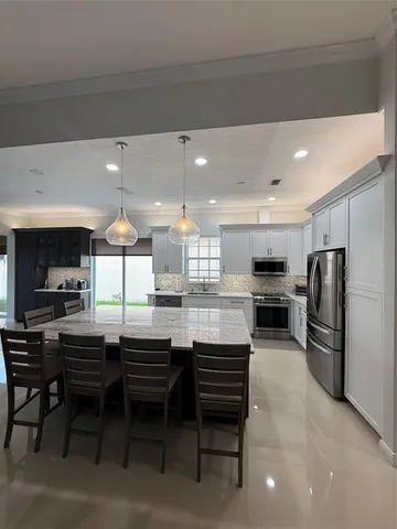 a kitchen with a sink stove and chairs