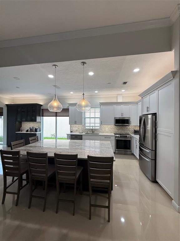 2752 Irma Lake Drive West Palm Beach, FL 33411 - Photo 9 of 38 a kitchen with stainless steel appliances kitchen island granite countertop a table chairs sink and cabinets