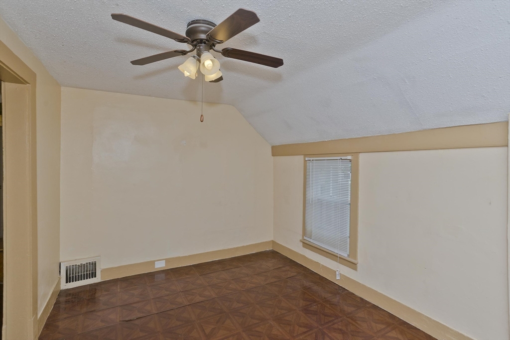 33 Forest Street Springfield, MA 01108 - Photo 16 of 39 an empty room with a chandelier fan and windows