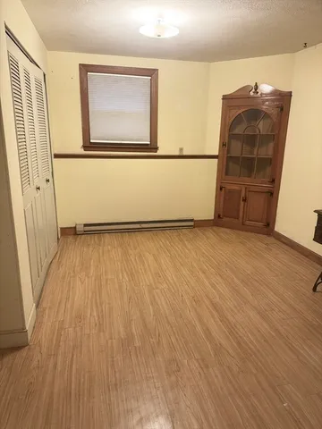 an empty room with wooden floor and cabinet