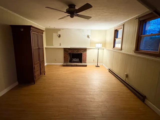 a view of a livingroom with wooden floor and a fireplace