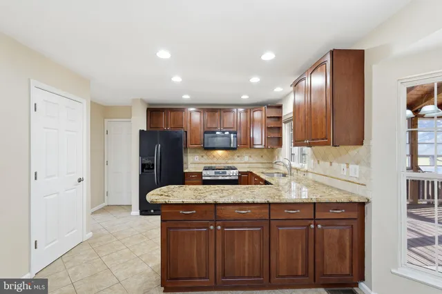 a kitchen with stainless steel appliances granite countertop a refrigerator and a sink