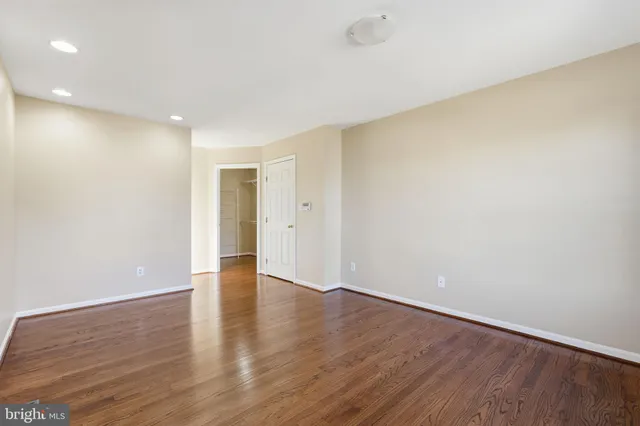 a view of an empty room with wooden floor