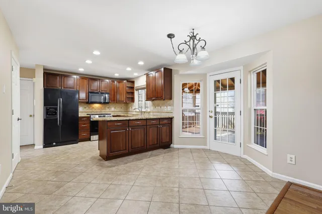 a large kitchen with a large counter top stainless steel appliances and cabinets