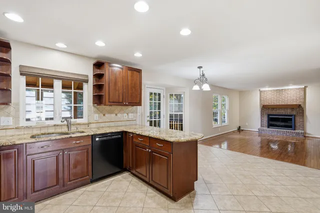 a large kitchen with a sink and dishwasher a oven with wooden cabinets