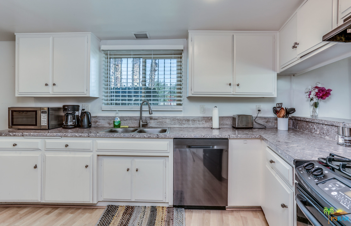 1855 Ramon Road, Unit 3 Palm Springs, CA 92264 - Photo 11 of 38 a kitchen with cabinets appliances a sink and a window
