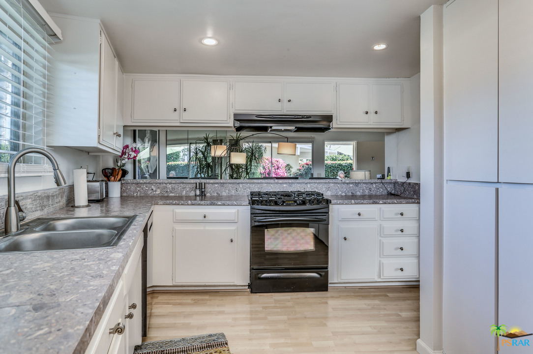 1855 Ramon Road, Unit 3 Palm Springs, CA 92264 - Photo 14 of 38 a kitchen with stainless steel appliances granite countertop a sink a stove and a refrigerator