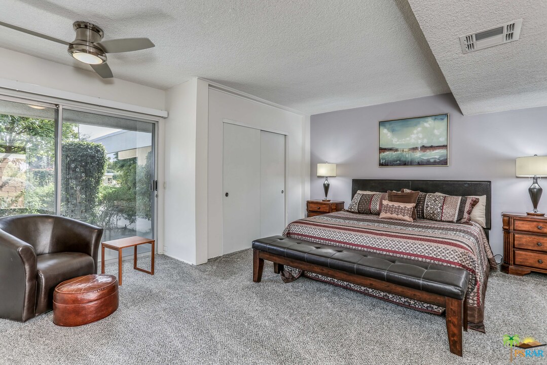 1855 Ramon Road, Unit 3 Palm Springs, CA 92264 - Photo 16 of 38 a spacious bedroom with a bed and a couch