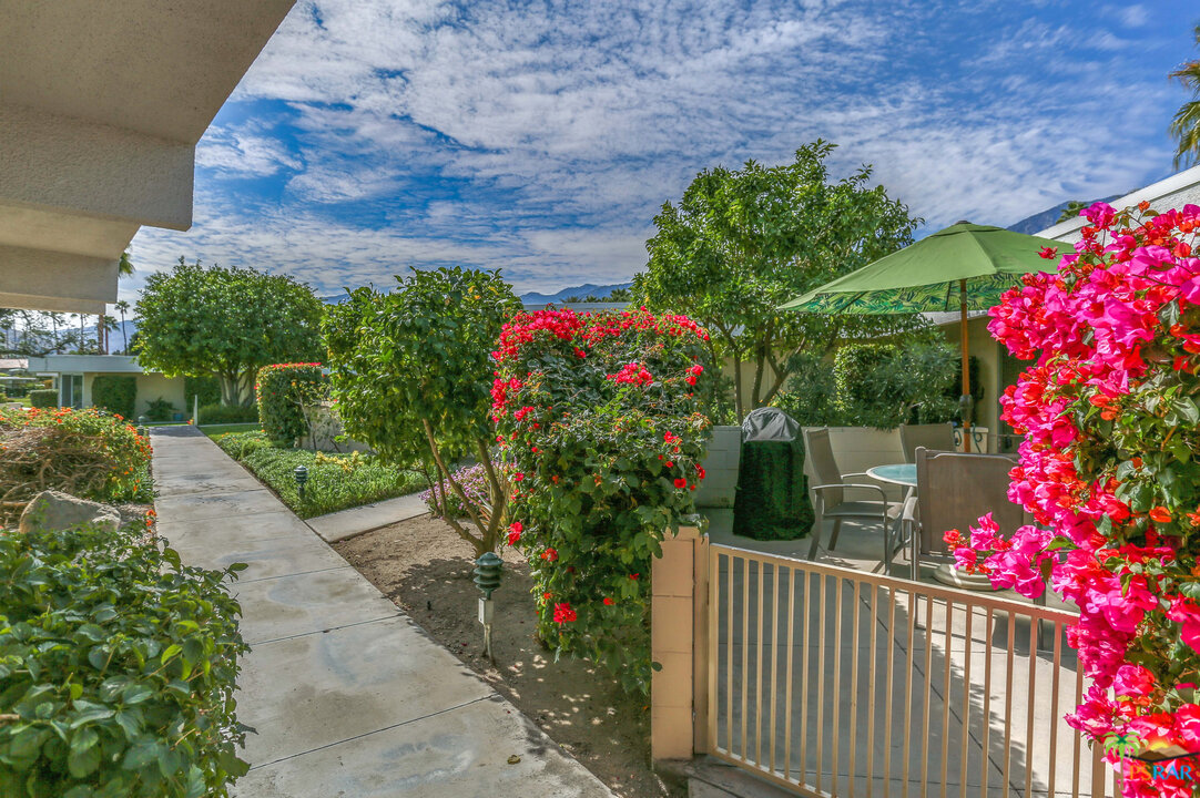 1855 Ramon Road, Unit 3 Palm Springs, CA 92264 - Photo 29 of 38 a green field with flowers and a white fence