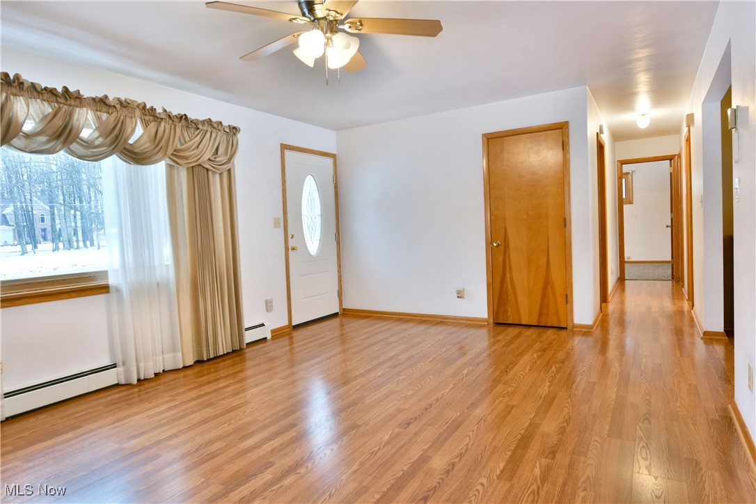 7155 Drake State Line Road Burghill, OH 44404 - Photo 8 of 50 Foyer entrance featuring light wood-style floors, a baseboard radiator, and a ceiling fan