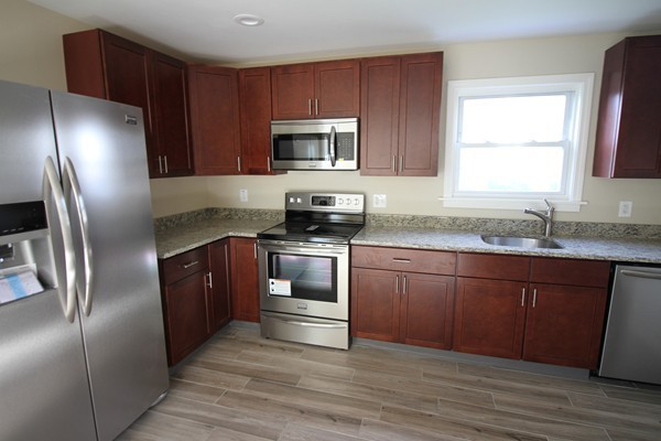 104 Sunapee Street Springfield, MA 01108 - Photo 2 of 11 a kitchen with granite countertop stainless steel appliances and wooden cabinets