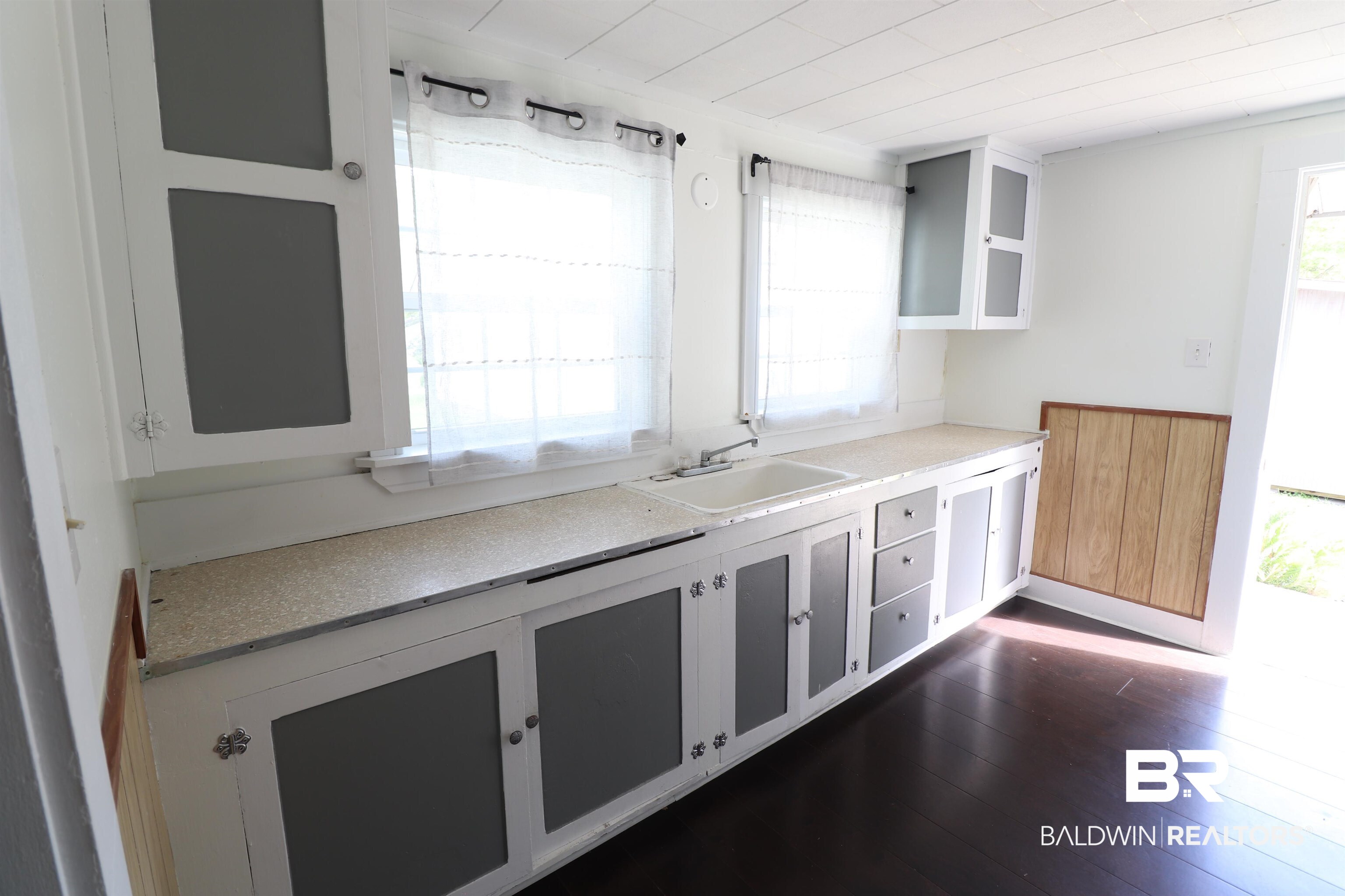 112 South Juniper Street Foley, AL 36535 - Photo 21 of 64 Kitchen with light countertops, white cabinets, and dark wood-type flooring