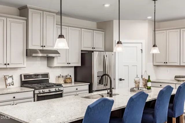 a kitchen with stainless steel appliances granite countertop sink stove top oven and refrigerator