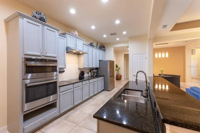 a kitchen with stainless steel appliances granite countertop a stove a sink and a refrigerator