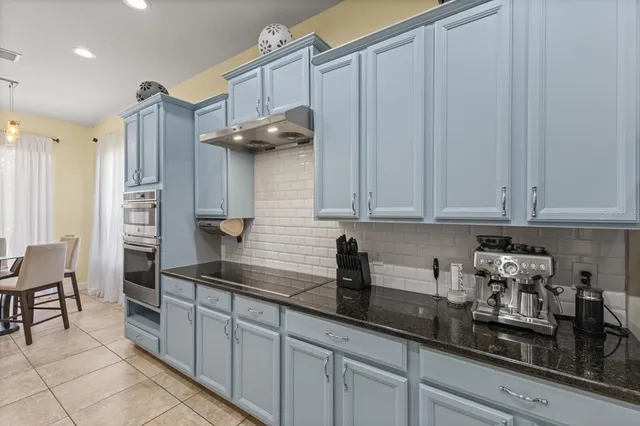 a kitchen with stainless steel appliances granite countertop a sink a stove and cabinets