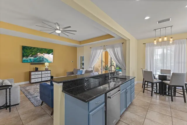 a kitchen island with granite countertop a table chairs and a sink