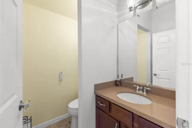 a bathroom with a granite countertop sink toilet and a mirror