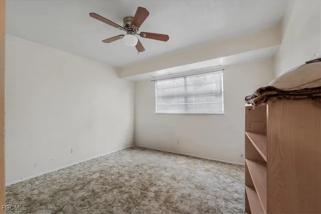 a view of empty room with wooden floor and ceiling fan