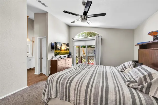 a bedroom with a bed and a large mirror on the dresser
