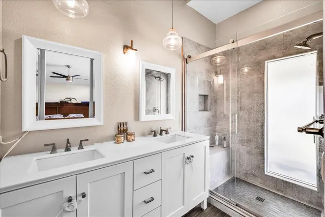 a bathroom with 2 sink shower and a mirror