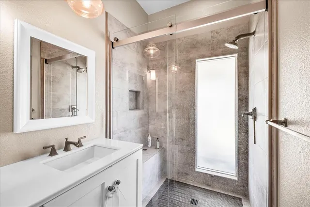 a bathroom with a double vanity sink mirror and shower