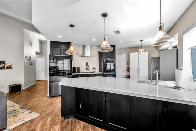 a large kitchen with kitchen island a sink stainless steel appliances and cabinets