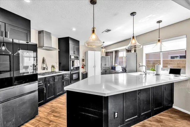 a large kitchen with kitchen island a sink counter space and stainless steel appliances