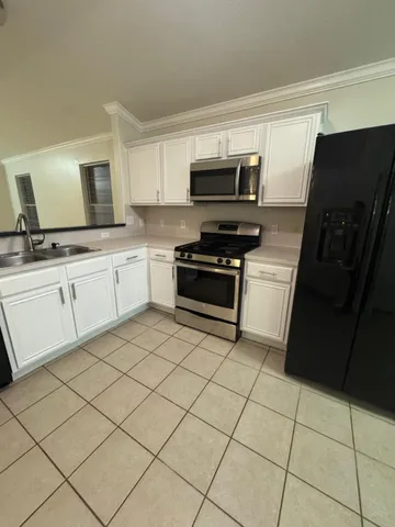 a kitchen with a sink a stove top oven and cabinetry