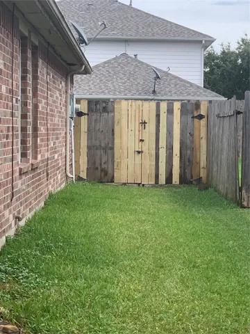 a view of a backyard with wooden fence