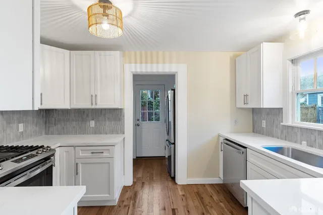 a kitchen with a stove and a white wooden cabinets