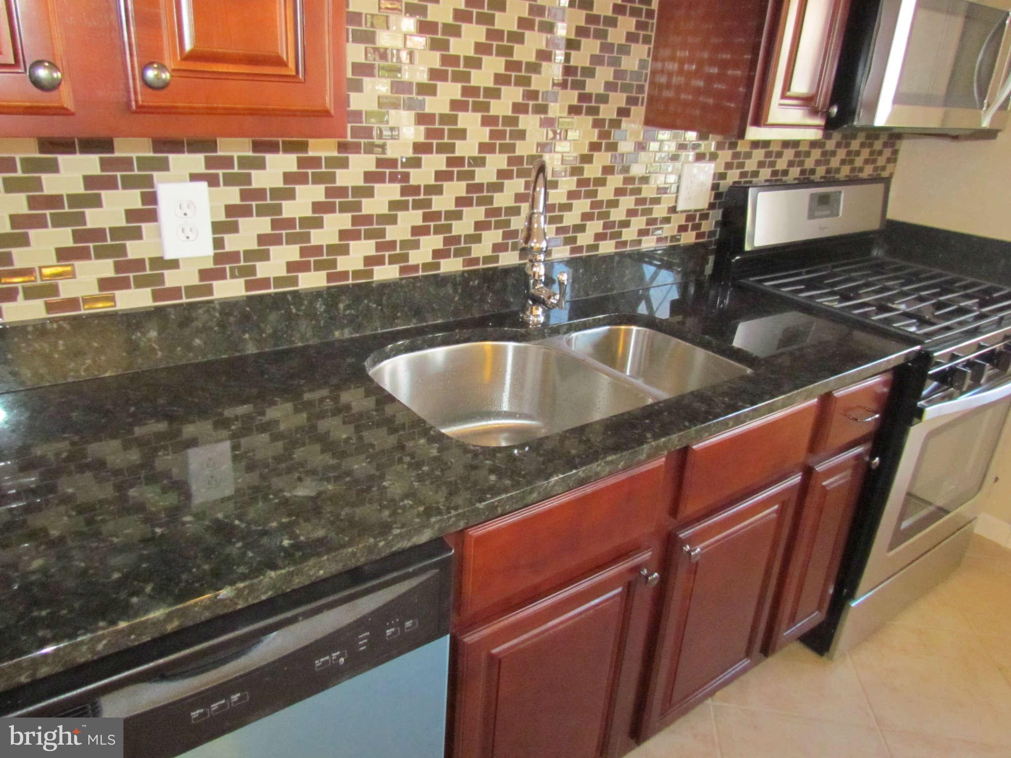 1808 Burnwood Road Baltimore, MD 21239 - Photo 3 of 25 a kitchen with granite countertop a sink and a stove