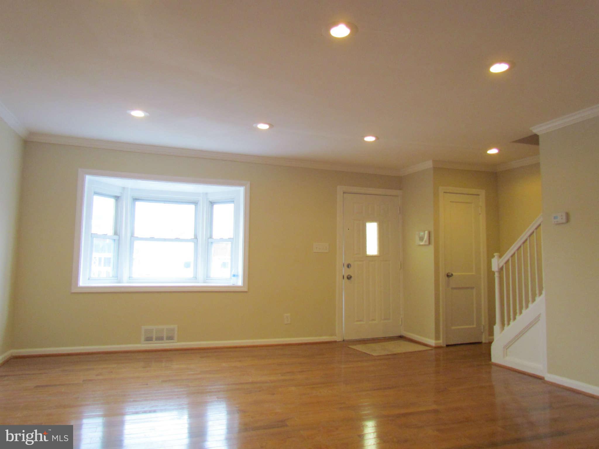 1808 Burnwood Road Baltimore, MD 21239 - Photo 21 of 25 a view of an empty room with wooden floor and a window