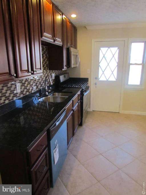 1808 Burnwood Road Baltimore, MD 21239 - Photo 22 of 25 a kitchen with granite countertop a stove and a sink