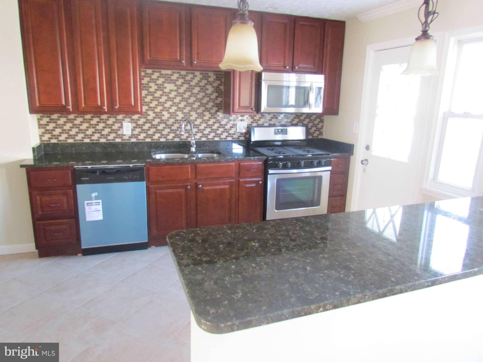 1808 Burnwood Road Baltimore, MD 21239 - Photo 4 of 25 a kitchen with stainless steel appliances granite countertop a stove a sink and a microwave