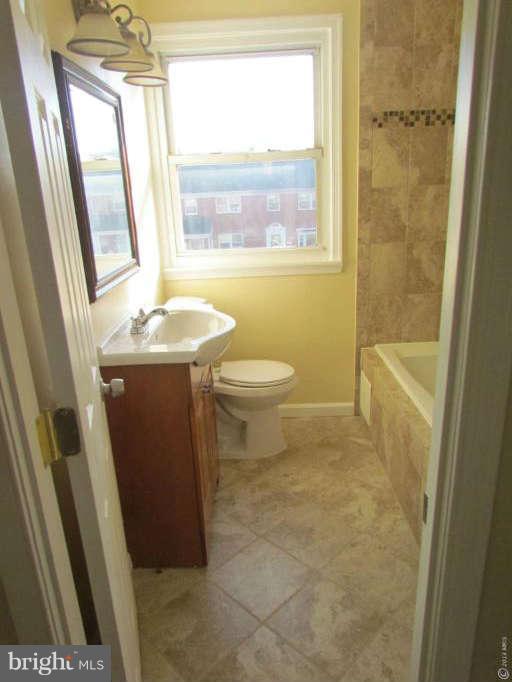 1808 Burnwood Road Baltimore, MD 21239 - Photo 10 of 25 a bathroom with a sink a toilet and a shower