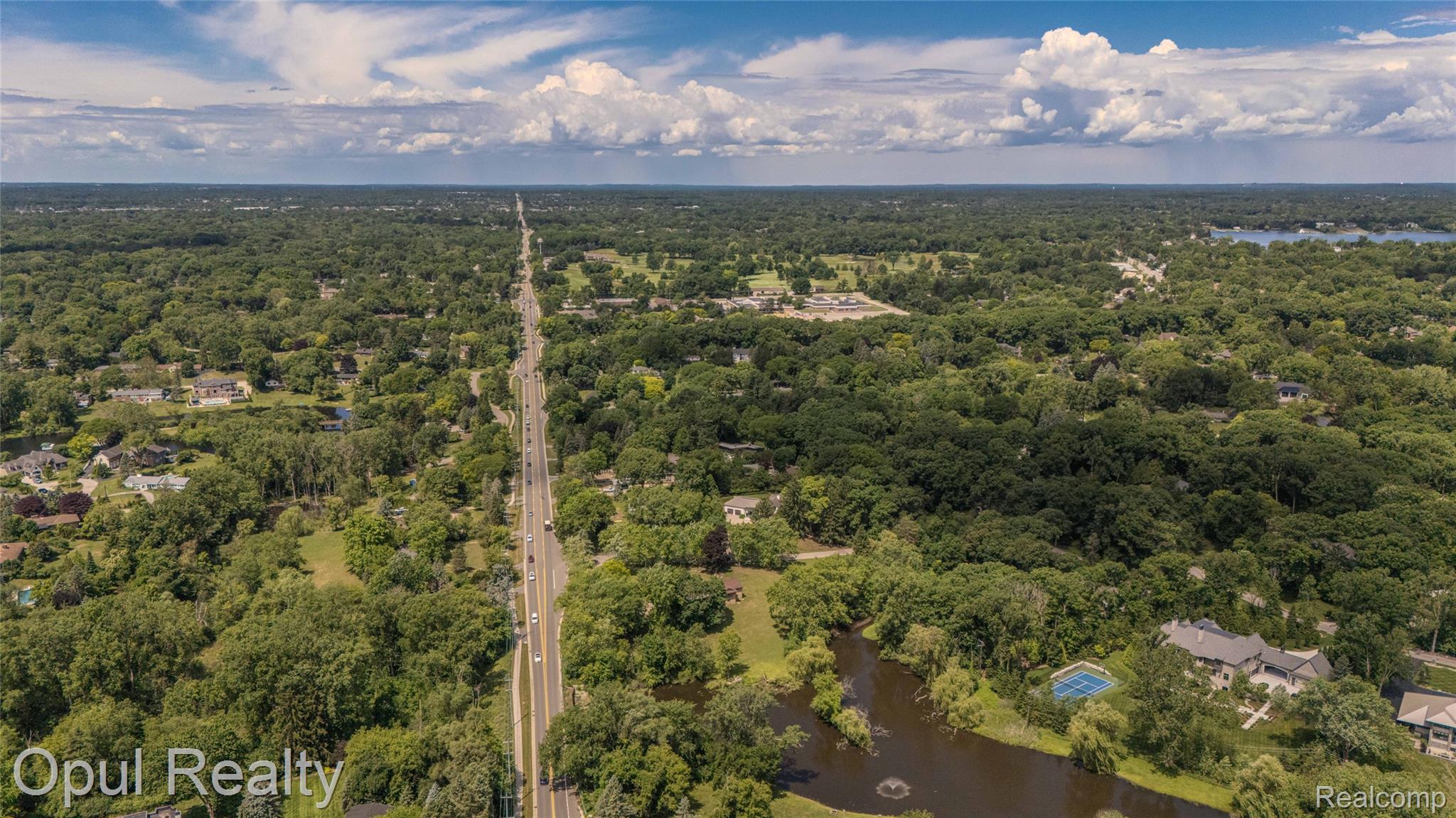6455 Norham Road Bloomfield Hills, MI 48301 - Photo 76 of 93 Expansive aerial perspective showcasing a verdant landscape with extensive tree coverage and a prominent roadway