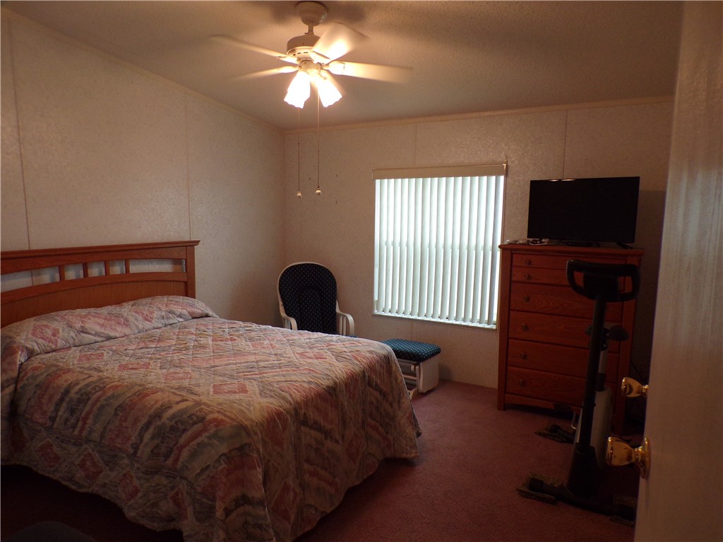 941 Wren Circle Sebastian, FL 32976 - Photo 13 of 16 a bedroom with a bed and a flat tv screen on dresser