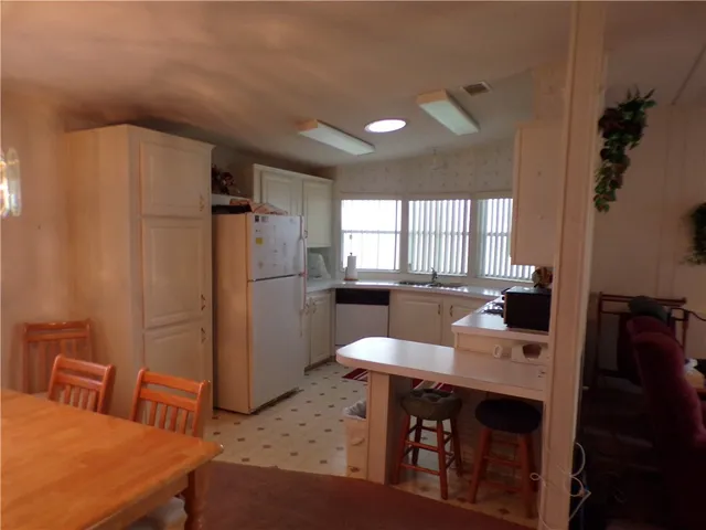 a kitchen with a table chairs and refrigerator